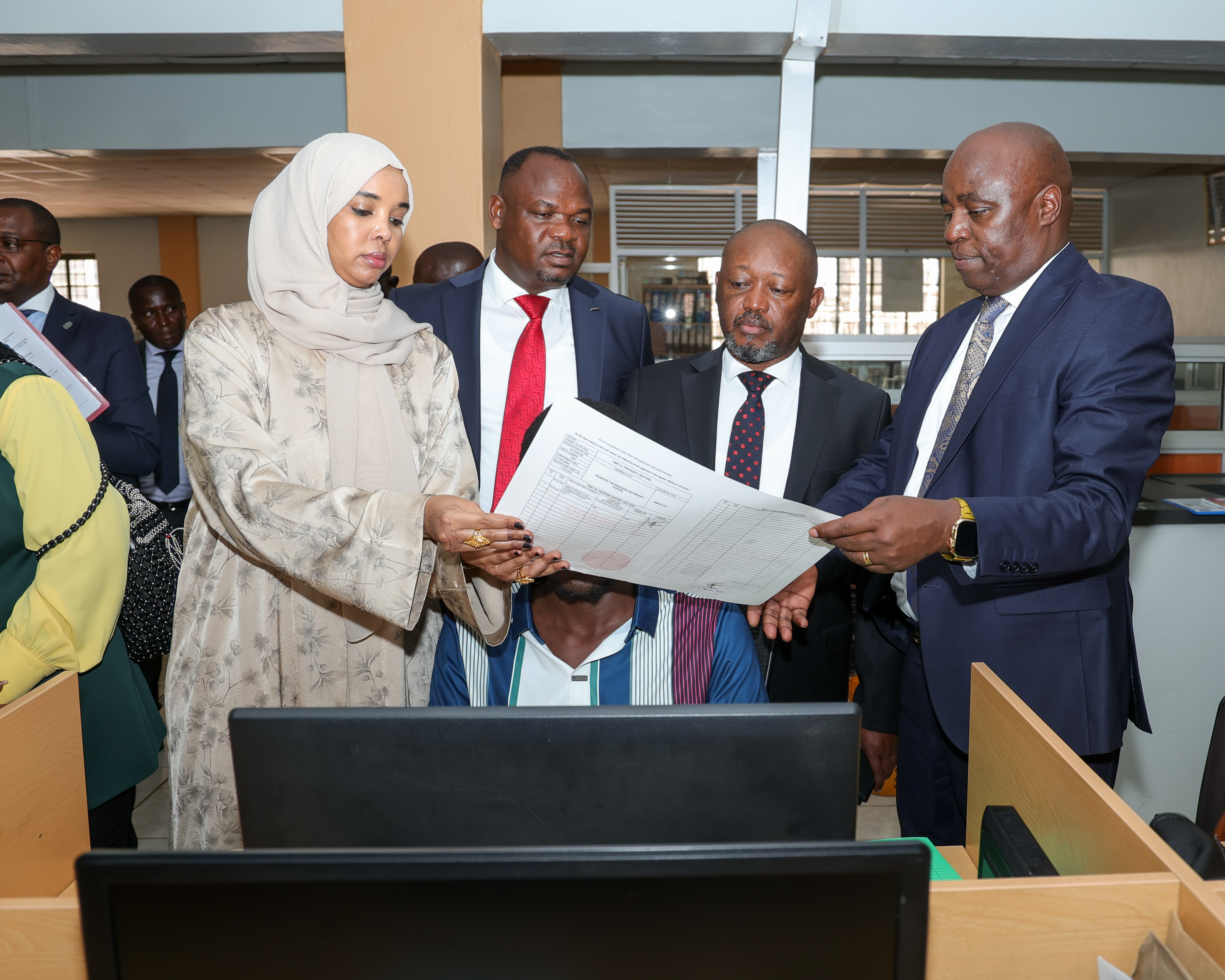 Members of the National Assembly Departmental Committee on Lands review the authentication and verification features of a title deed