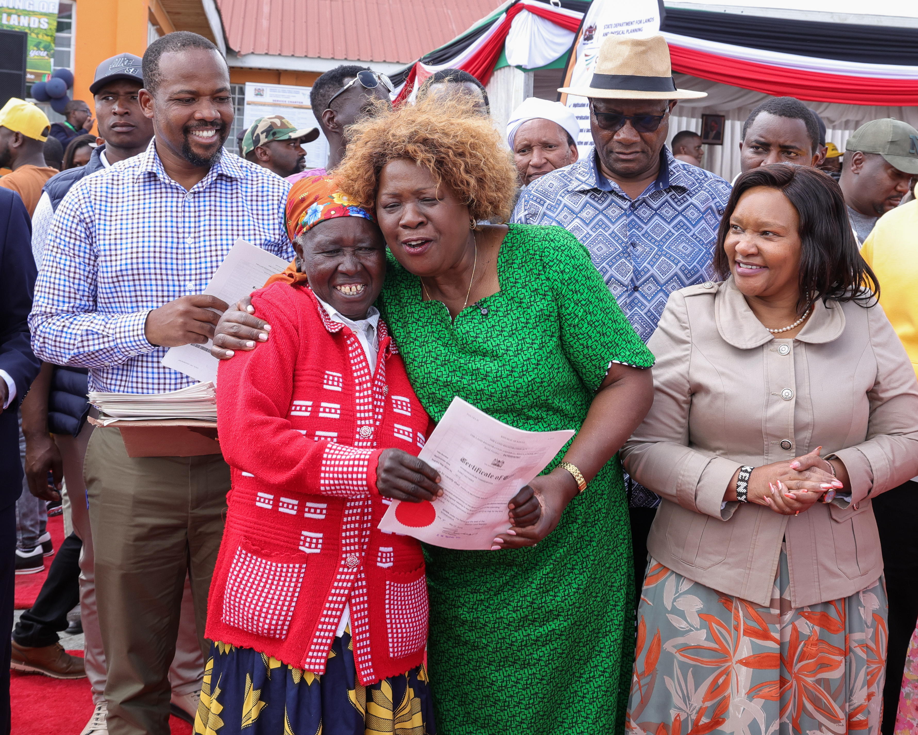 Cabinet Secretary Alice Wahome embraces a beneficiary after presenting a title deed during the Colonial villages titling exercise